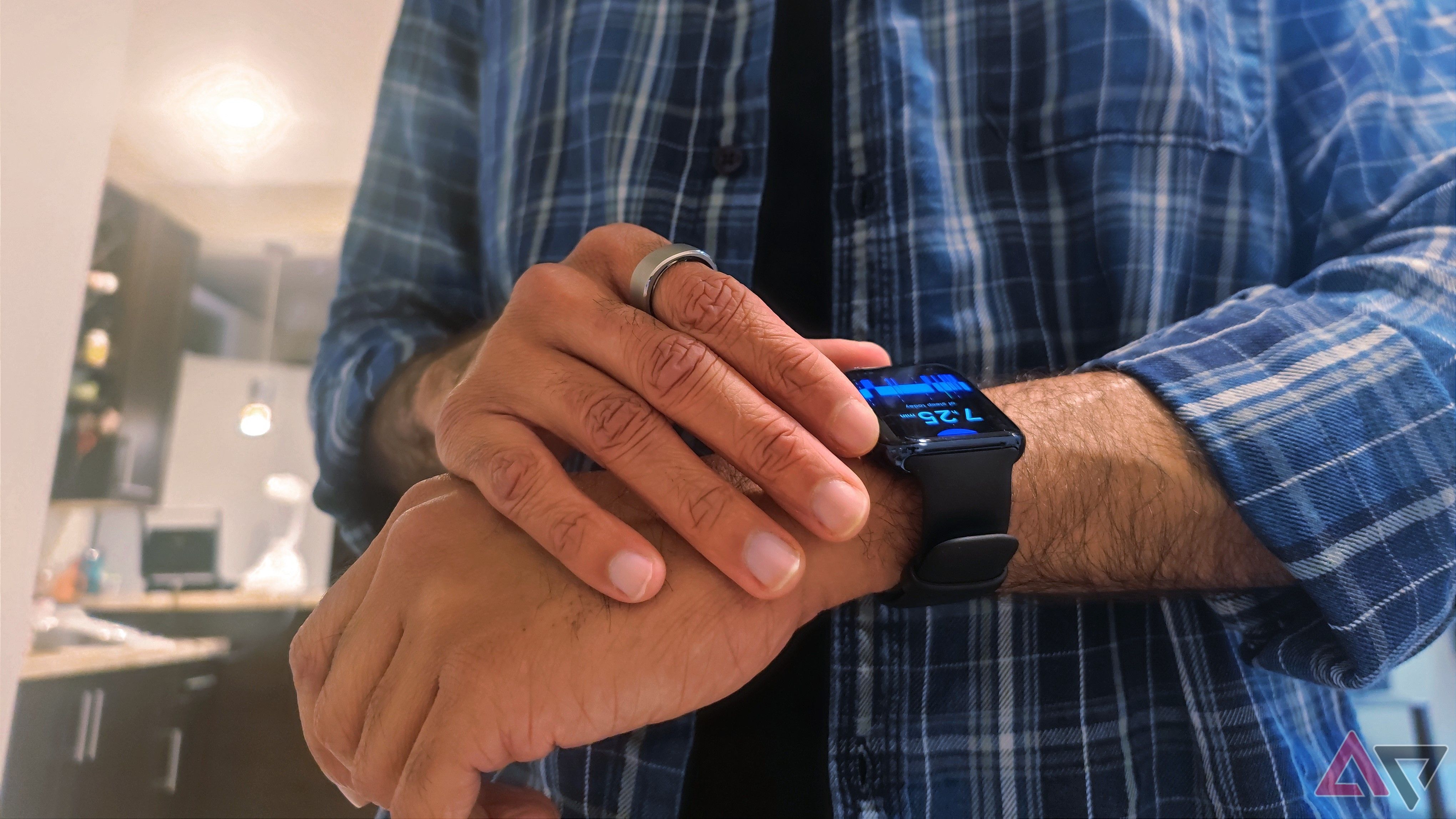 A person wearing a smart ring while using a smartwatch