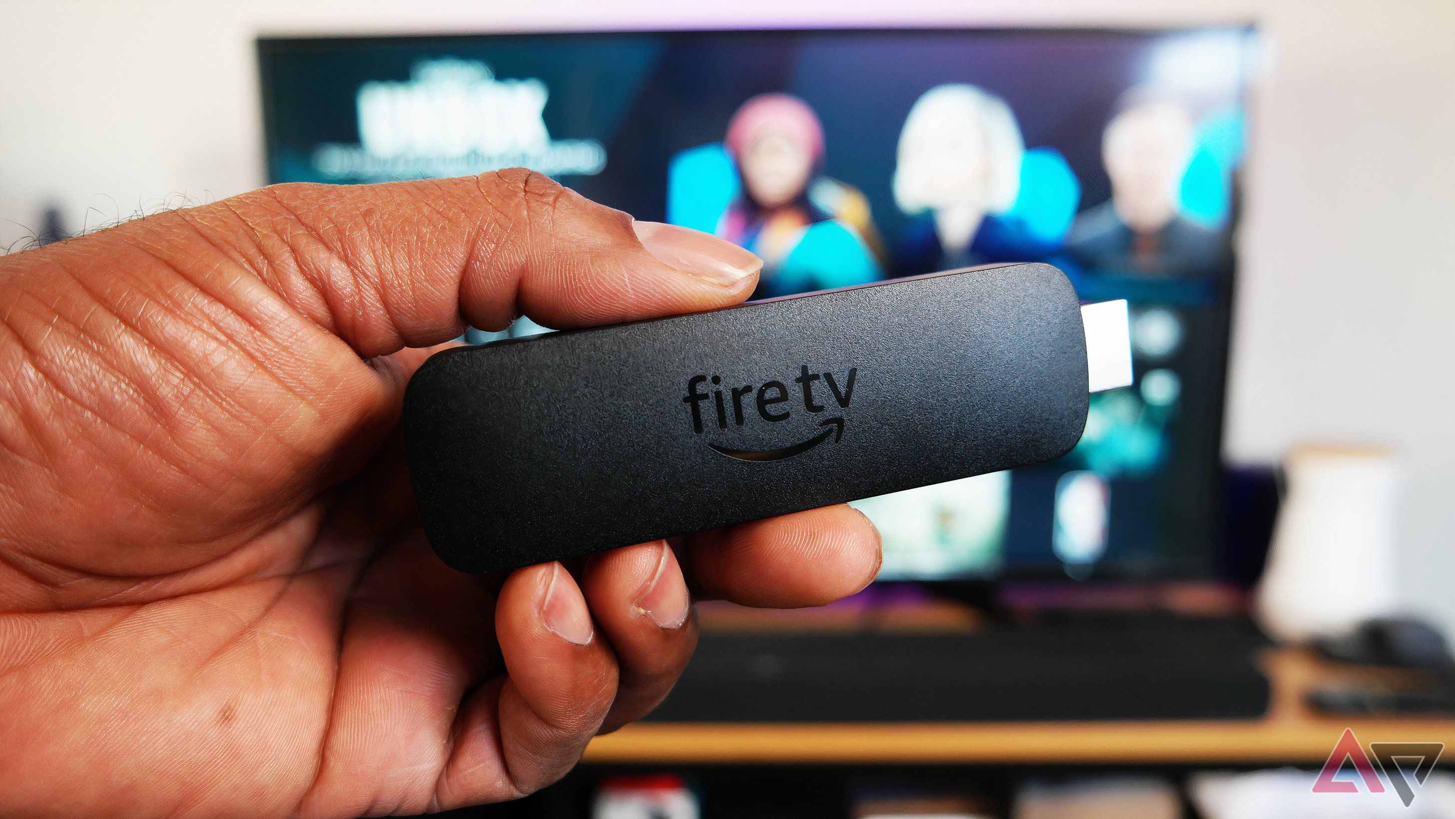 Amazon Fire TV Stick 4K body only, shown in front of TV running Fire OS