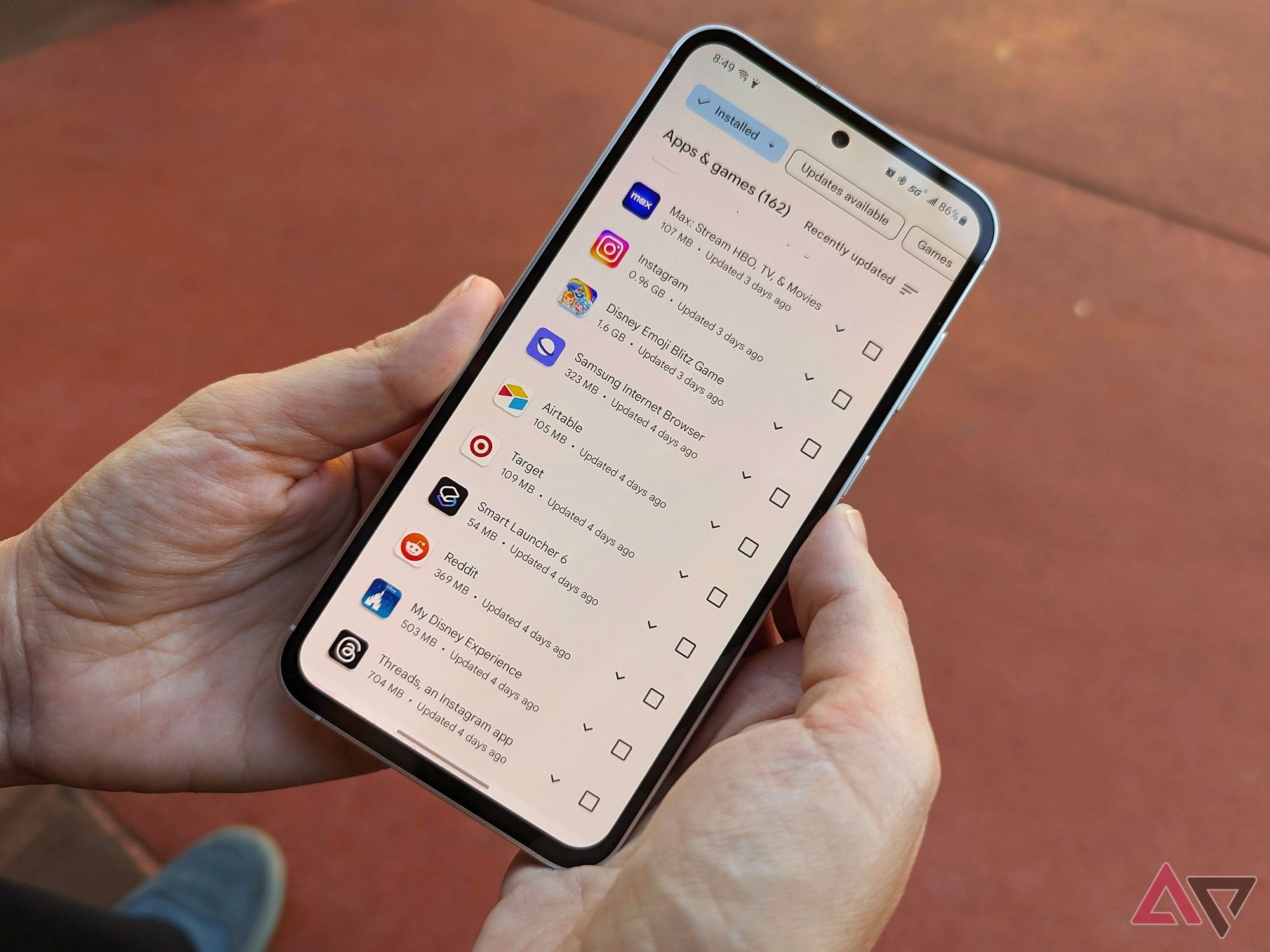 The Google Play Store displayed on the Samsung Galaxy S23 FE while someone holds it.