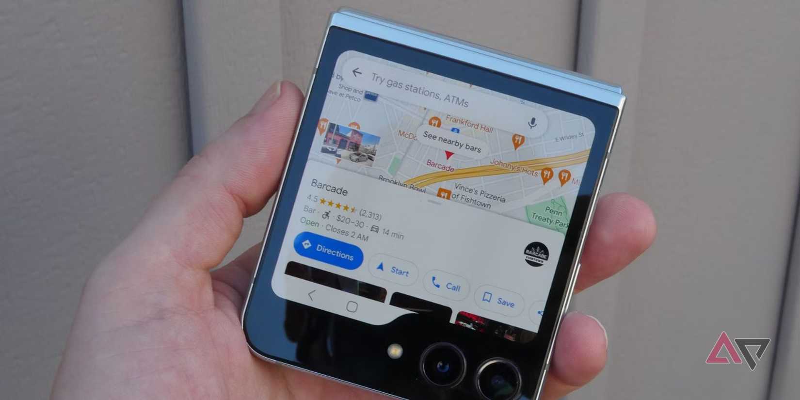 The Google Pixel 9a standing upright in a park, with the purple back showing towards the camera.