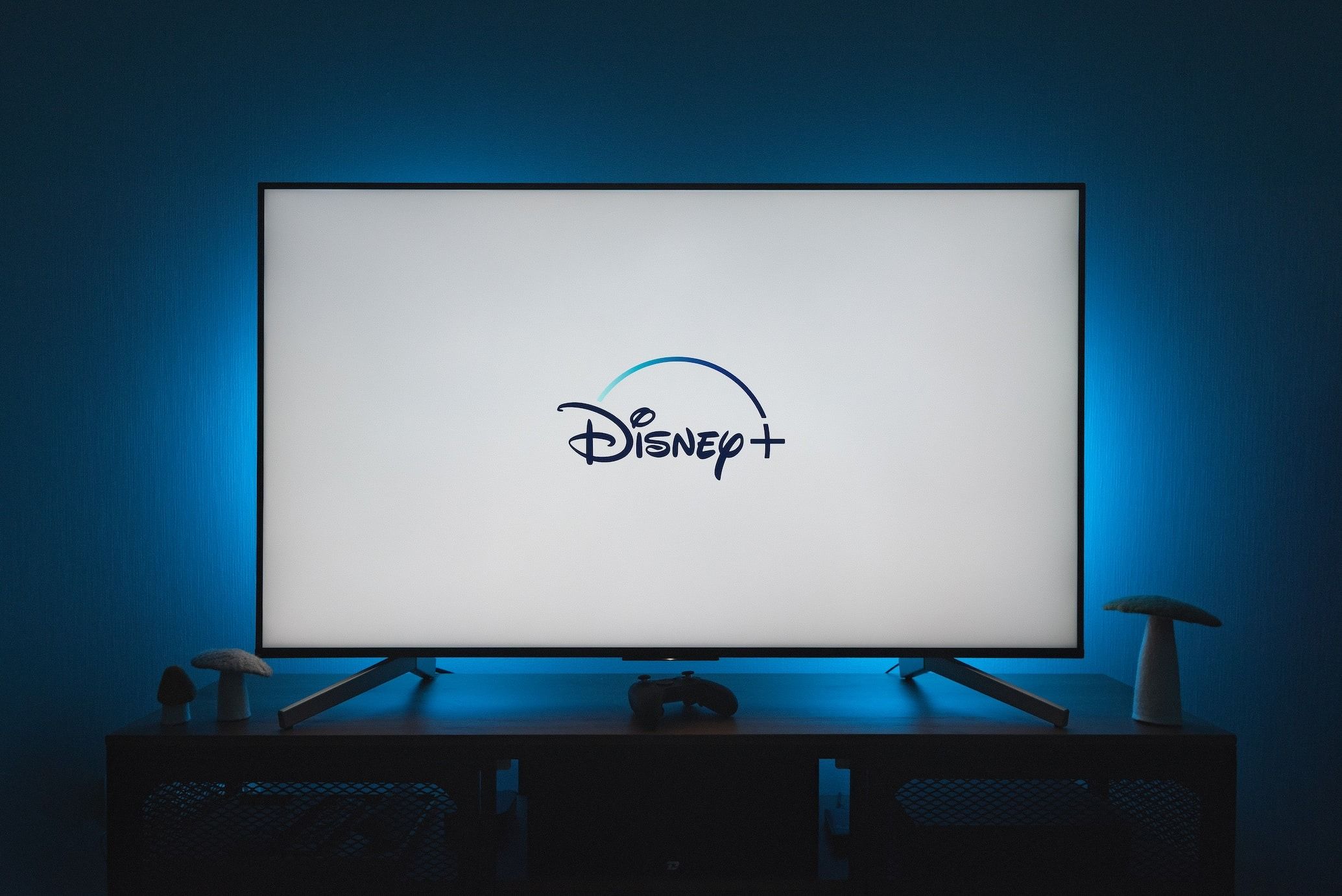 flat screen tv sitting on table with disney plus logo on white background