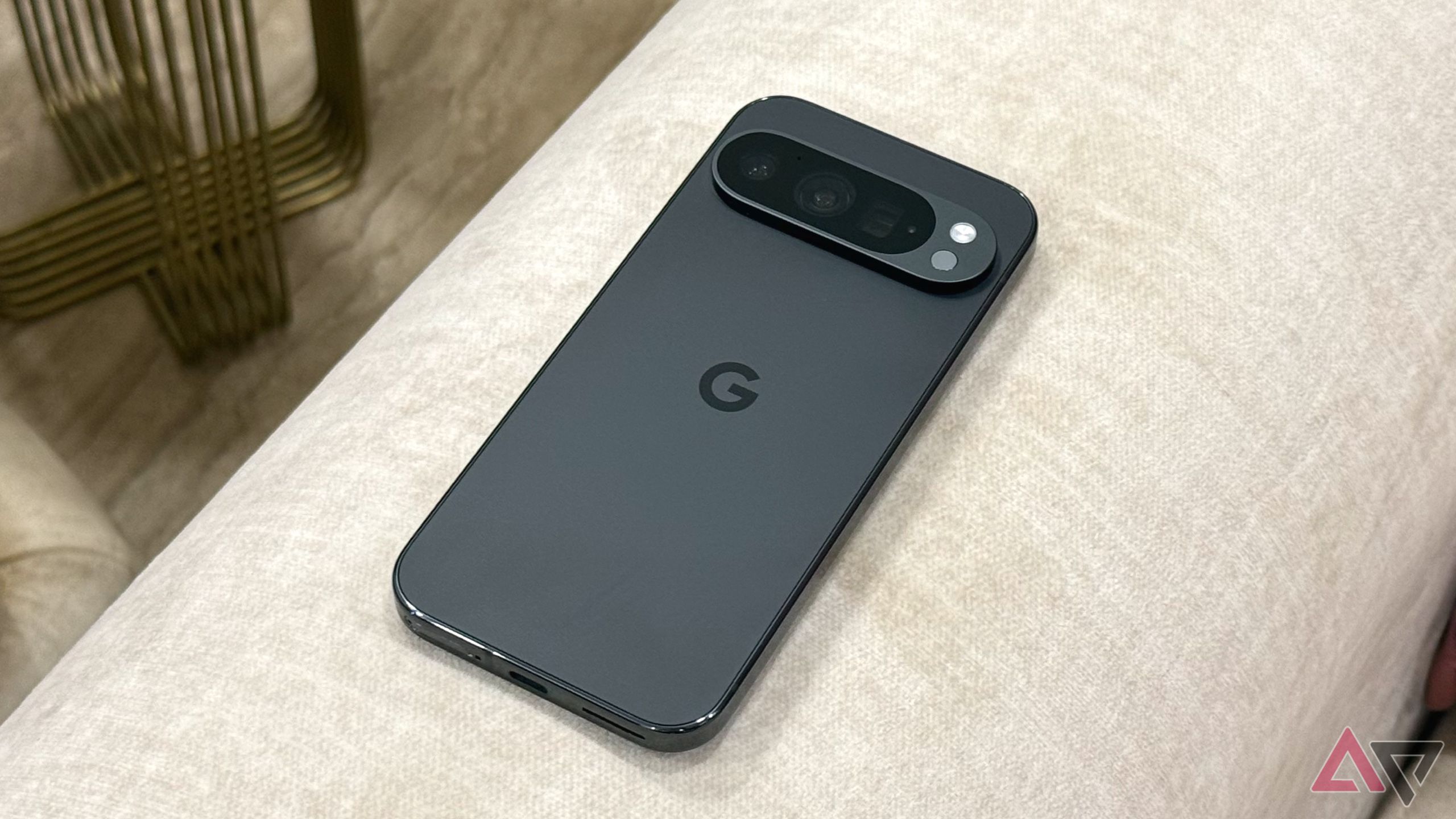 The Google Pixel 9a on a wooden bench in a park, face down.