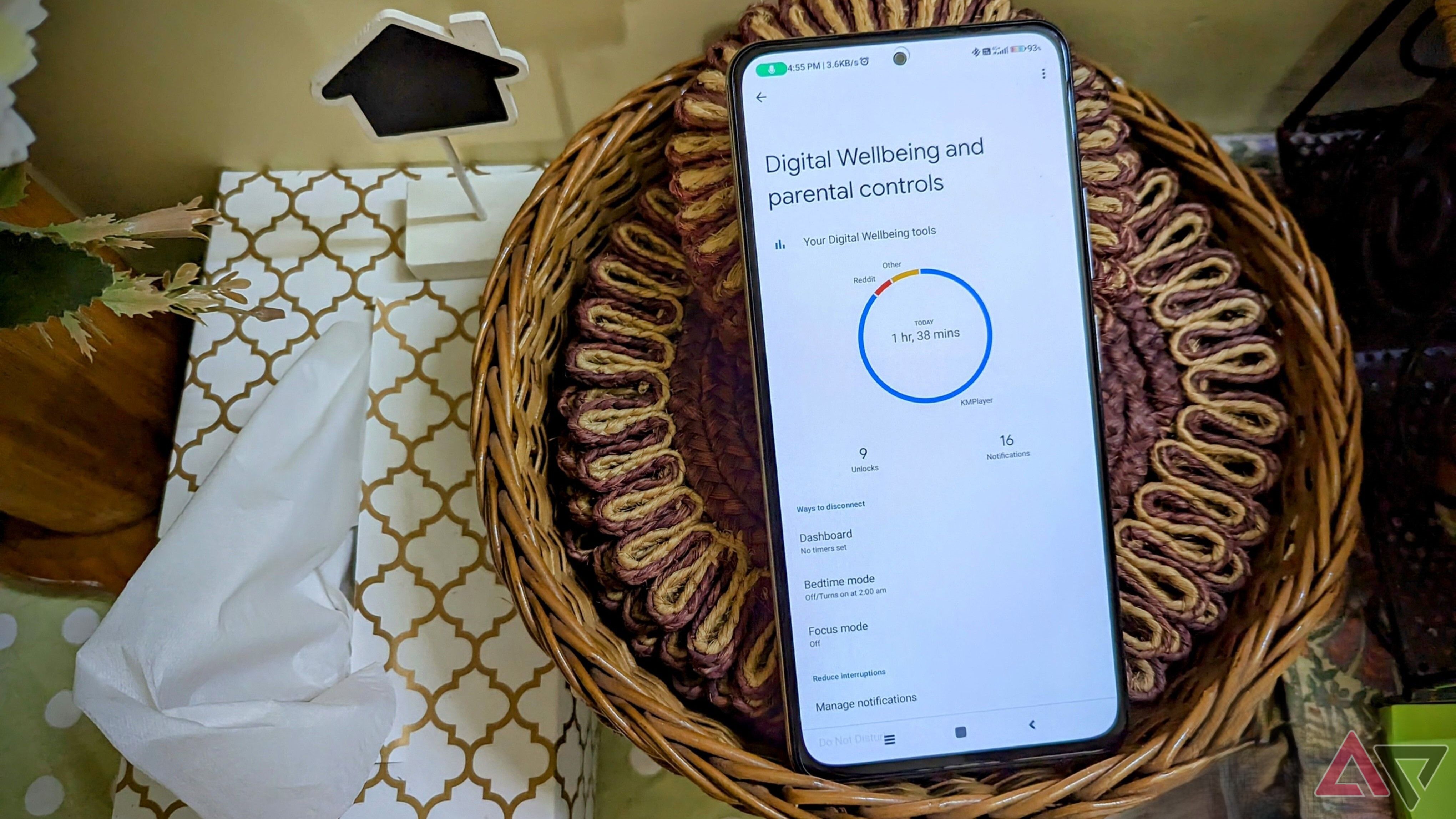 A google Pixel with the Android 16 logo sits stands on a table 