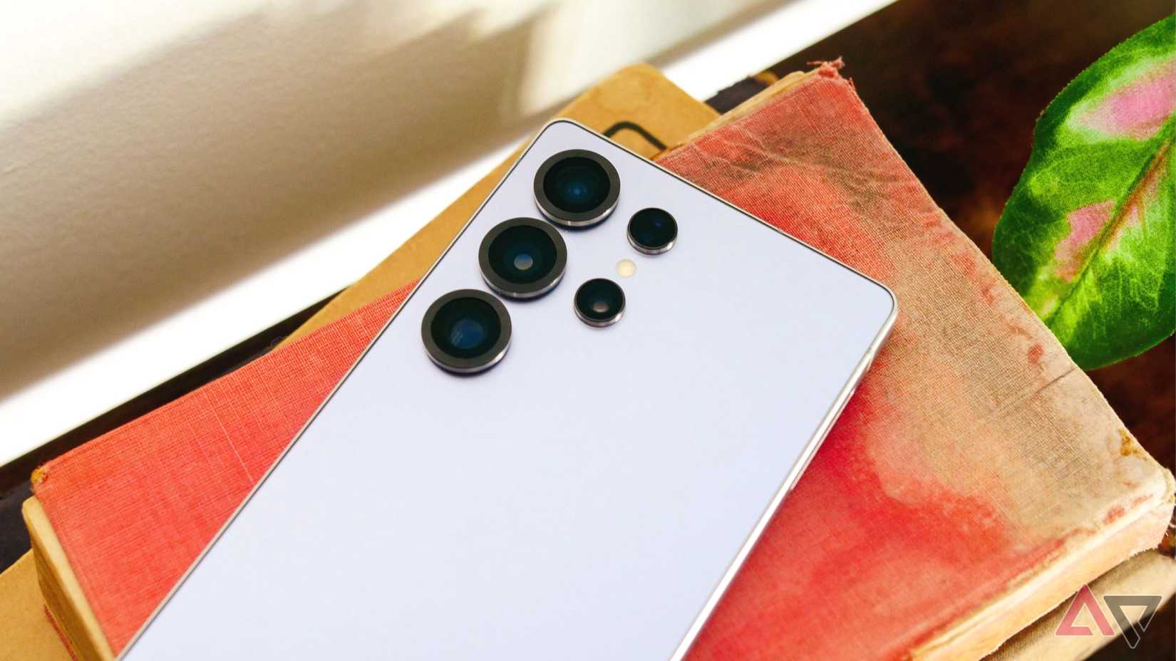A hand holding a Google Pixel covered by a red cloth with 'AI' written behind, and some AI sparkles around.