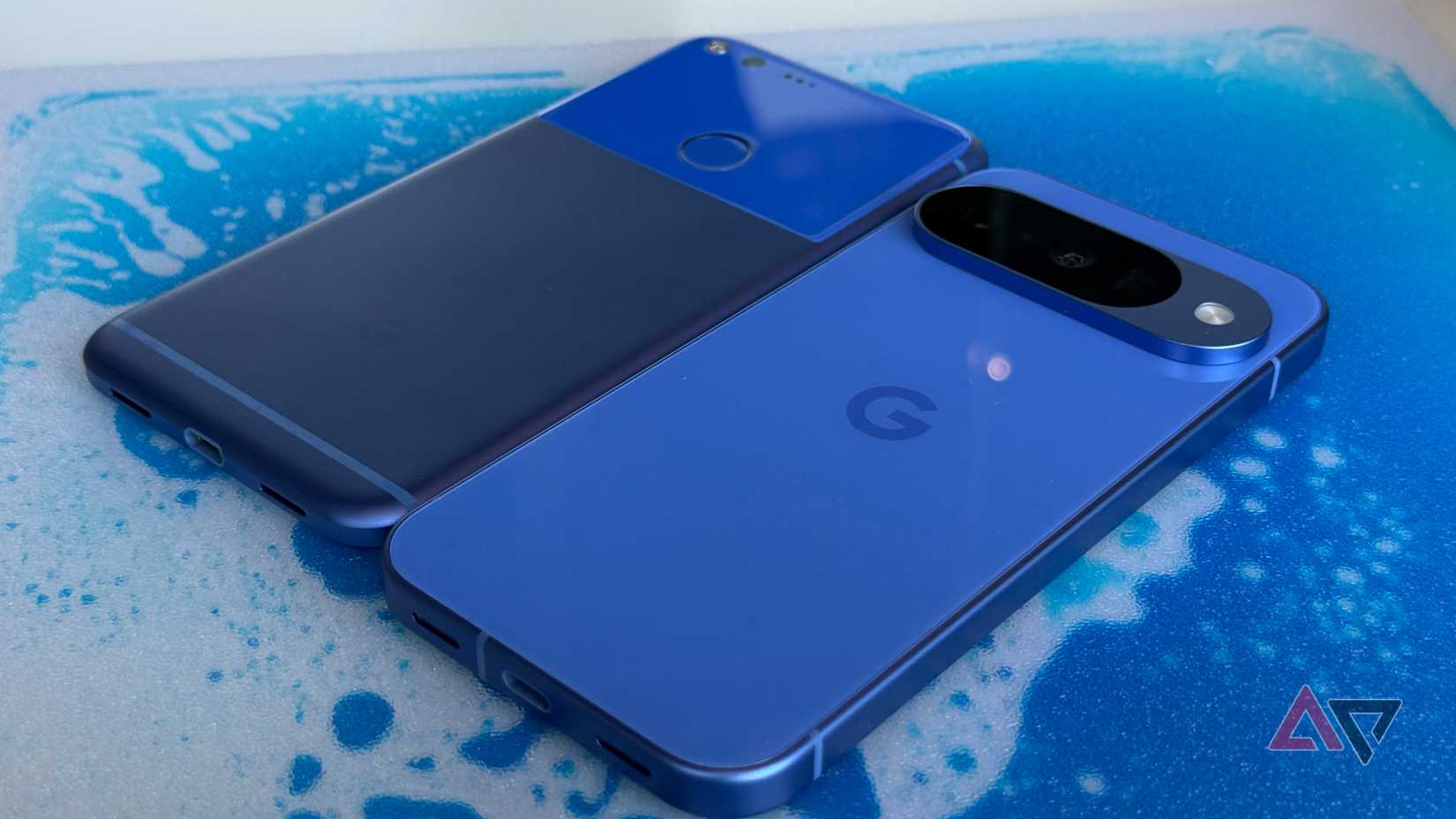 Google Pixel 9a laying on top of a Google Pixel 9 Pro XL