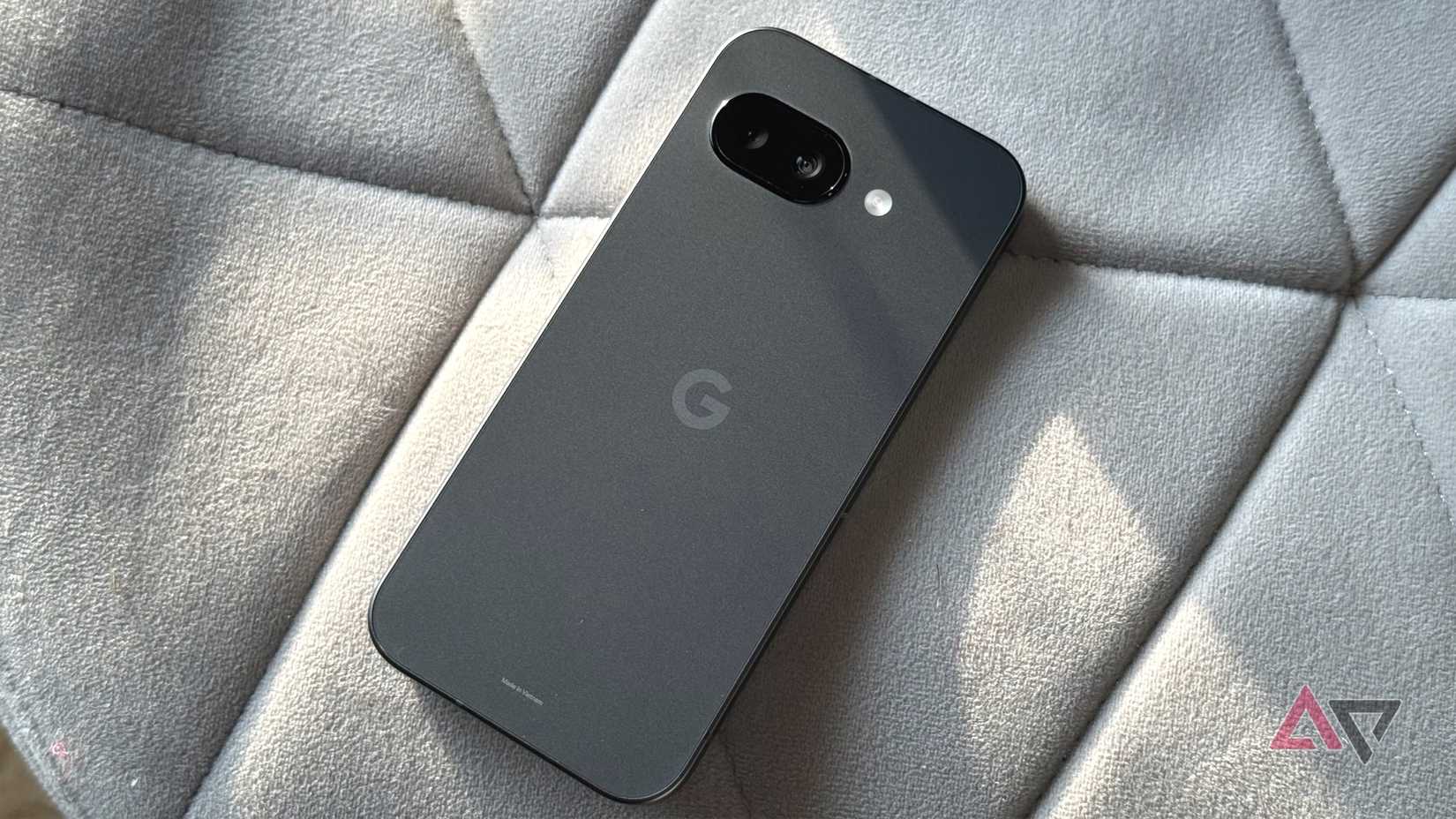 Google Pixel 9a in peony sitting next to a Pusheen with popcorn