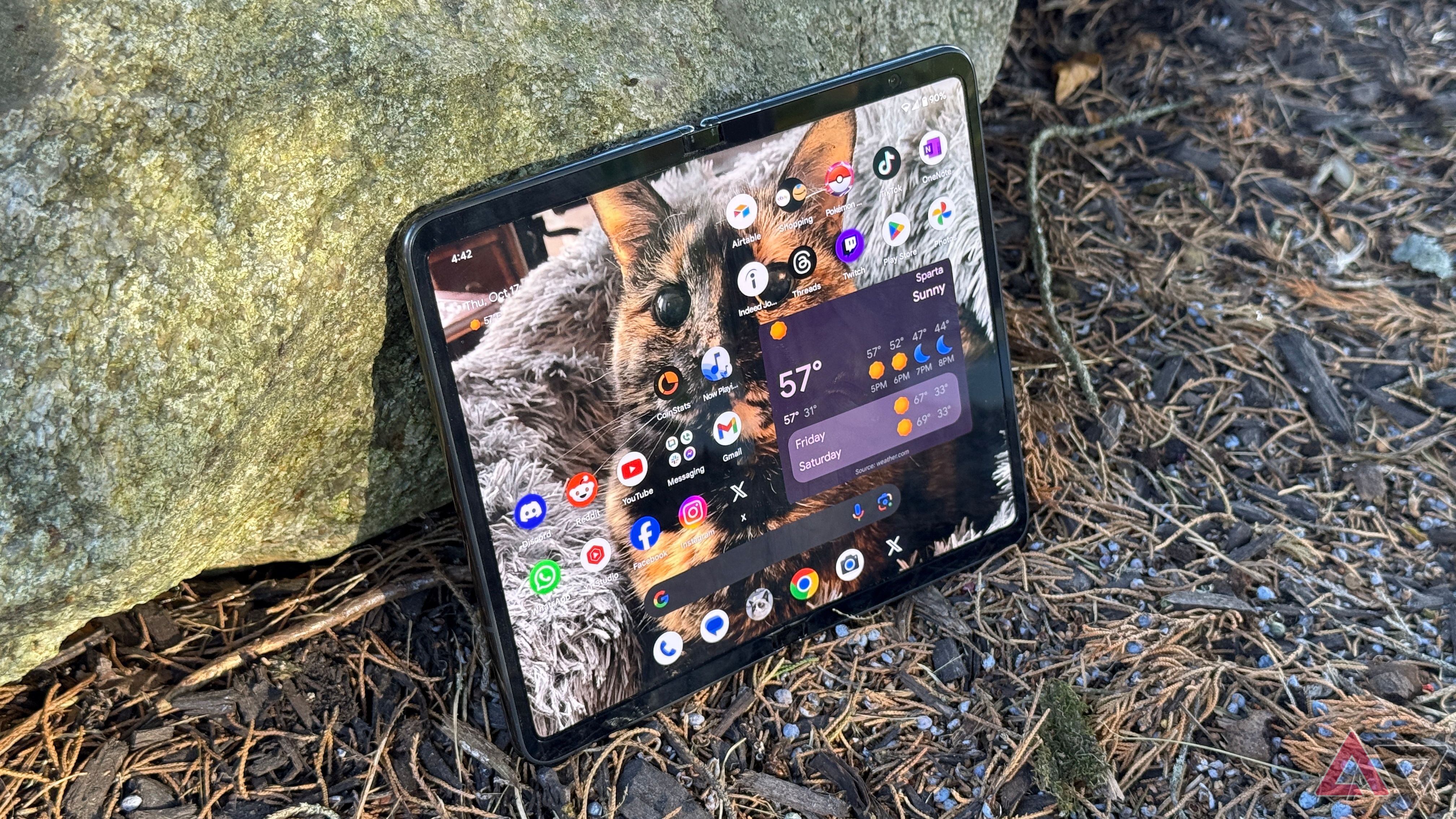 Google Pixel Fold laying up against a rock outdoors
