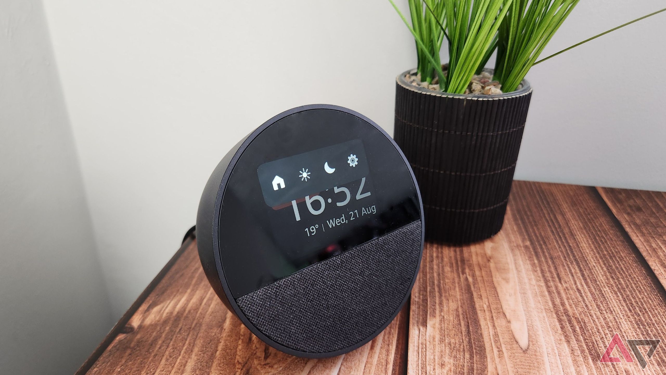 Amazon Echo Spot on a wooden table next to a green plant showing the menu options