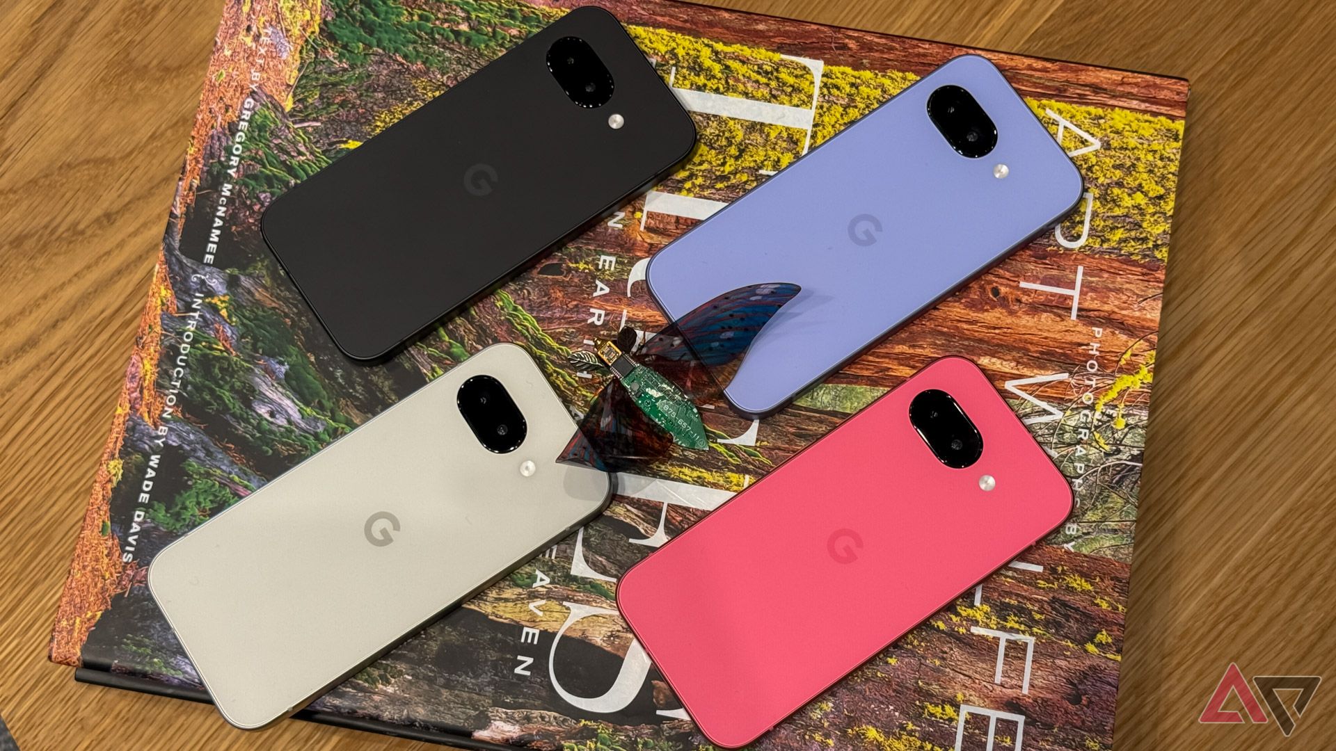 The Pixel 9a family face down on a book.