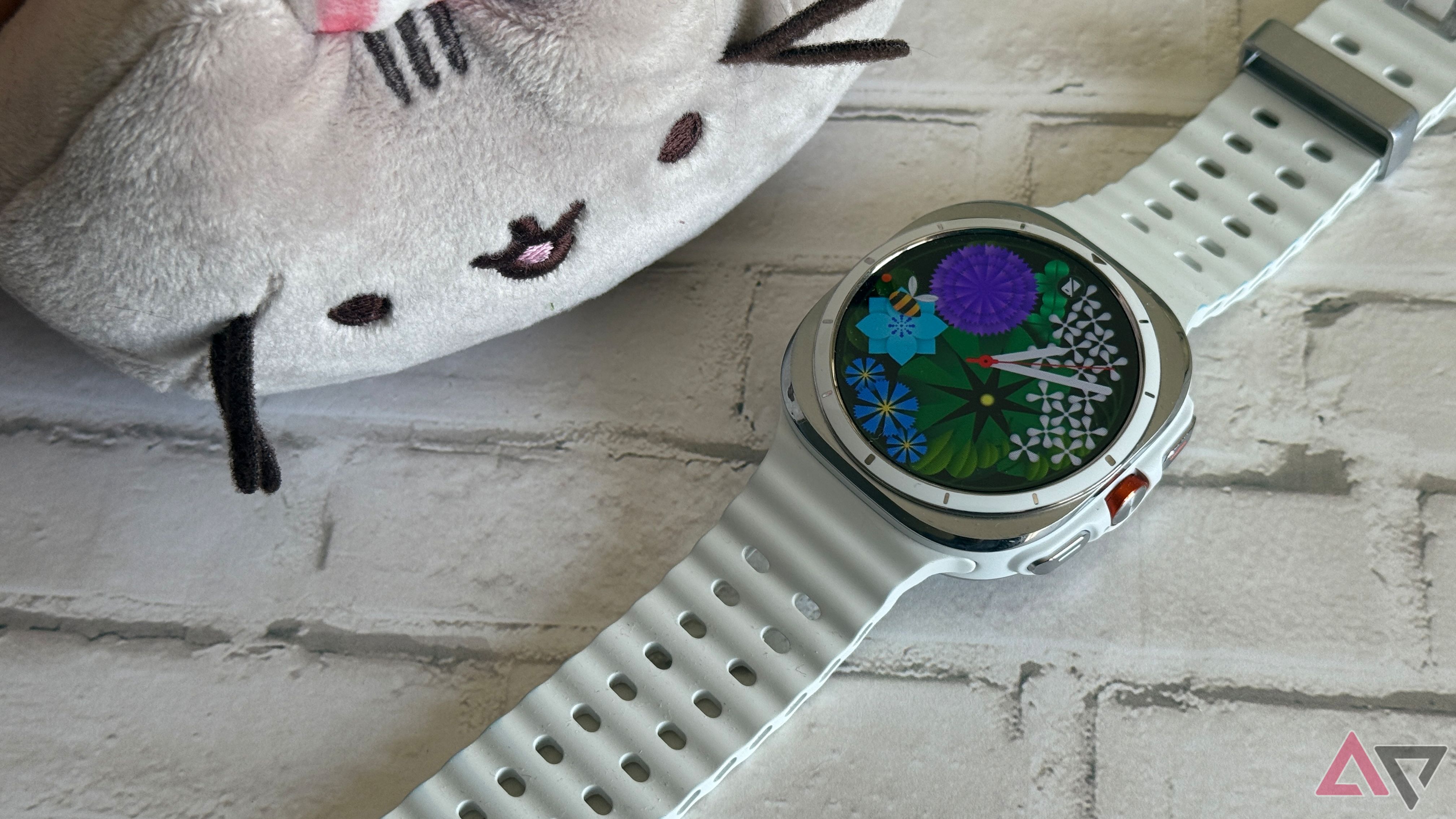 Samsung Galaxy Watch Ultra sitting next to Pusheen wearing bunny ears