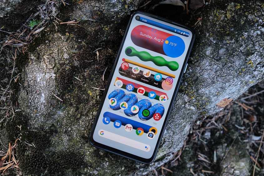 A Google Pixel 9 Pro, with its prominent camera bar, resting facedown on stones.