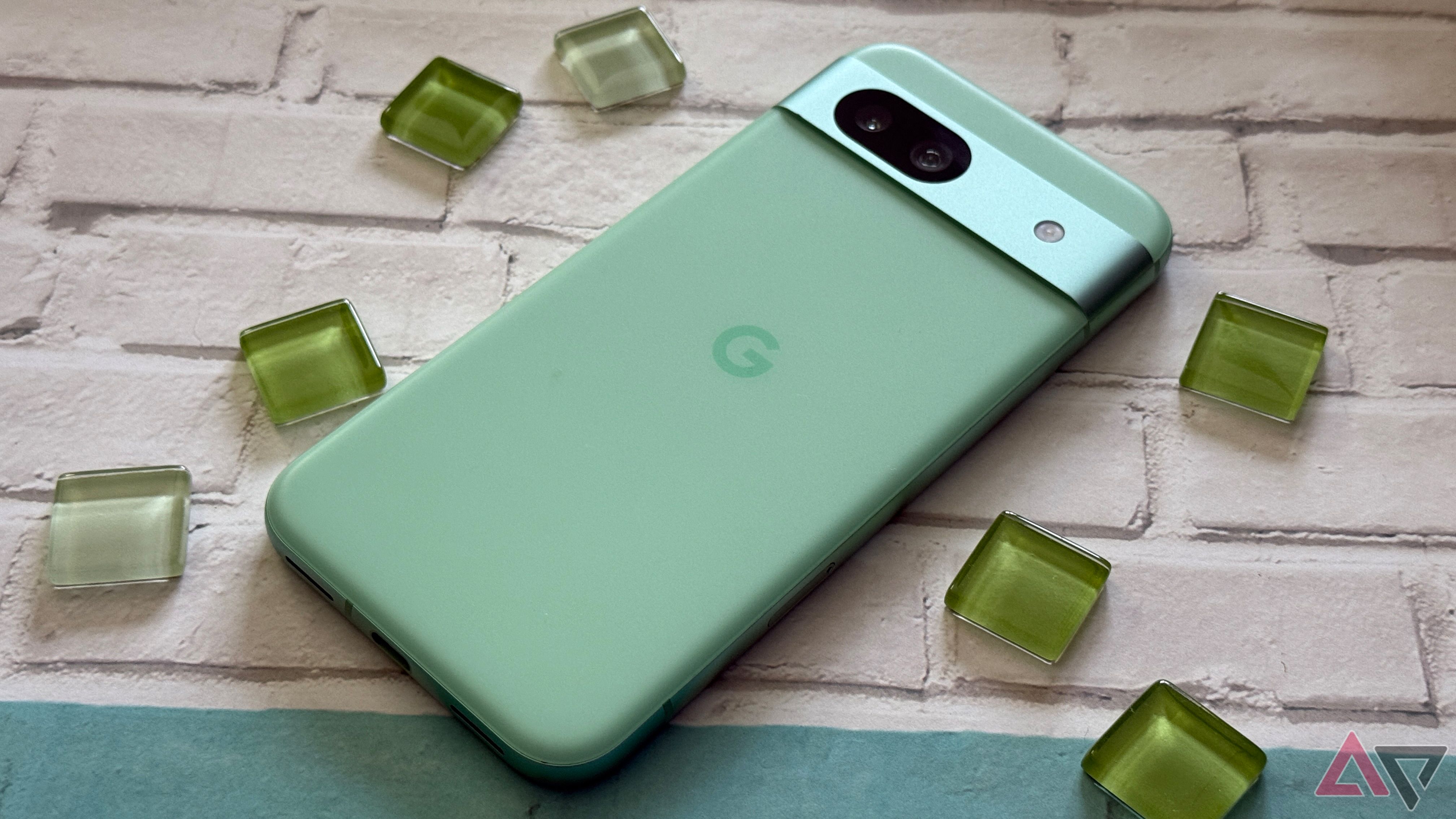 Google Pixel 8a in green surrounded by glass beads