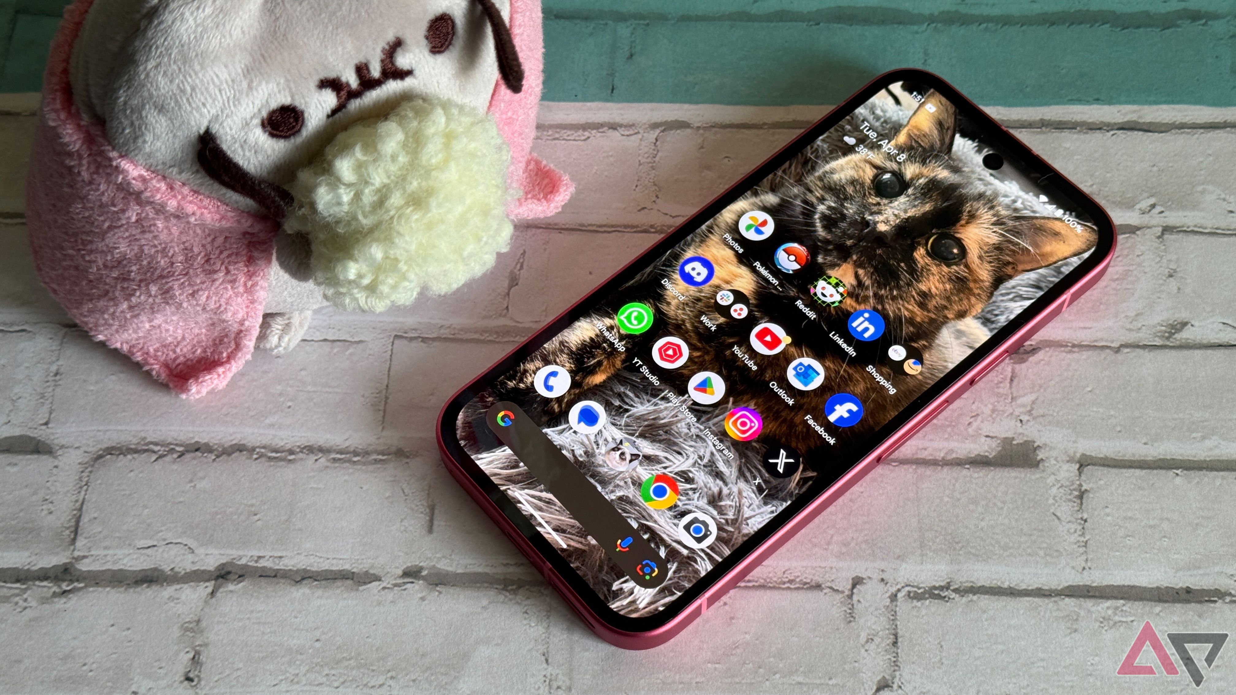 Google Pixel 9a laying on a mat next to Pusheen with some popcorn