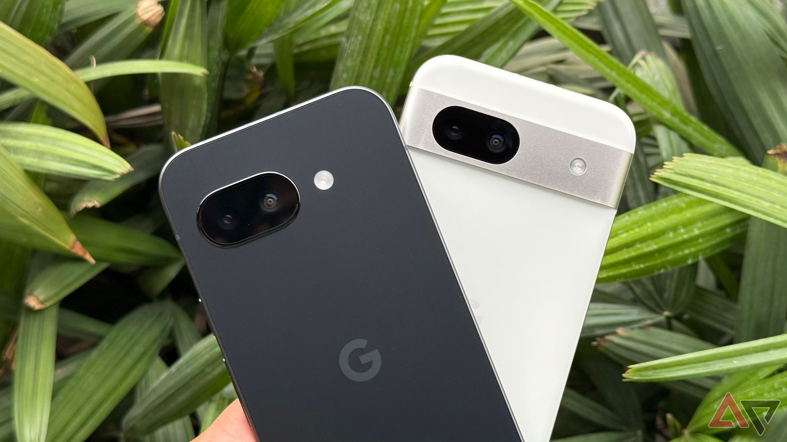 Close-up of the Google Pixel 9a and Pixel 8a in black and white finishes respectively