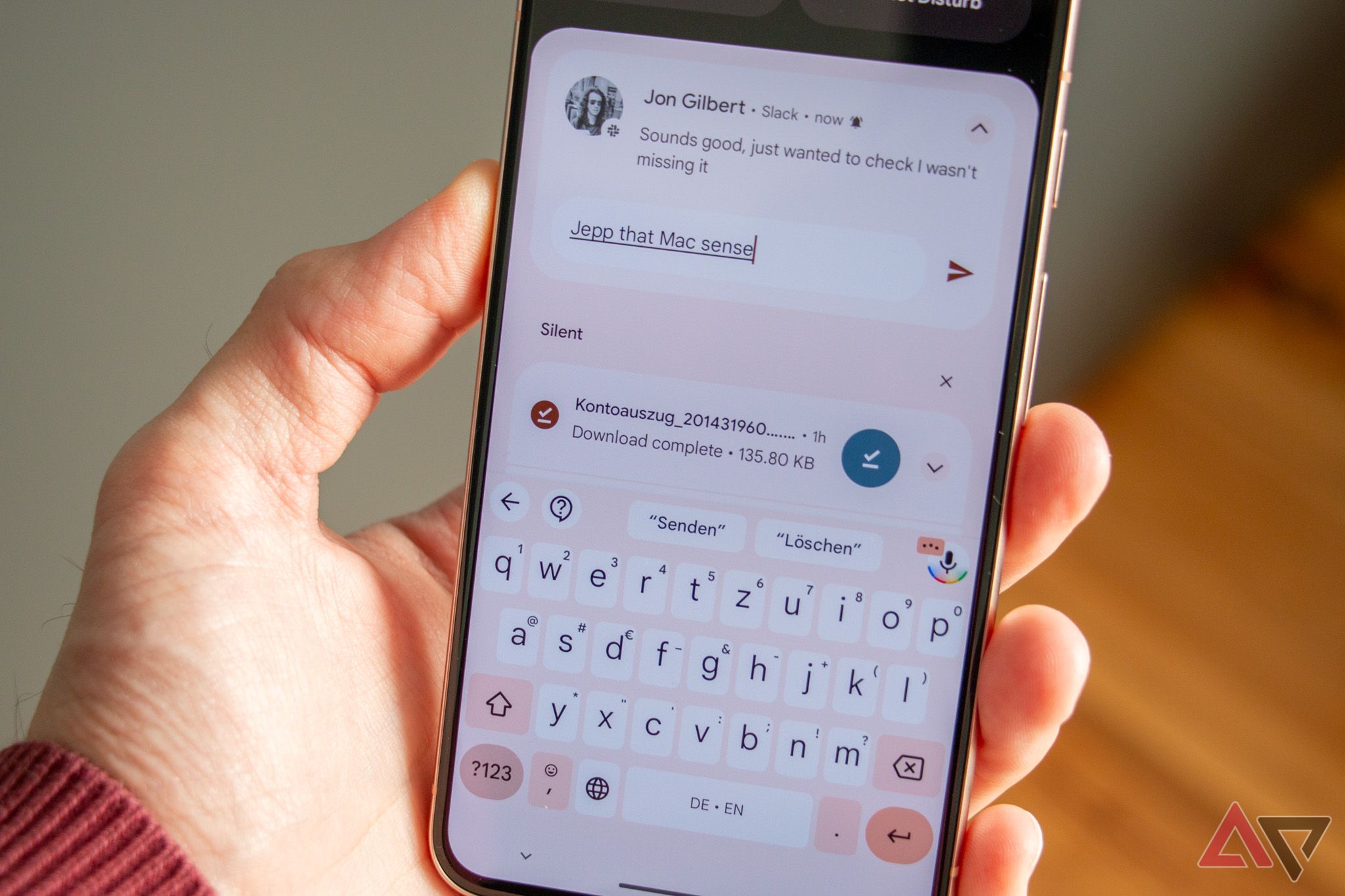 Hand holding pixel 8 with keyboard app open.